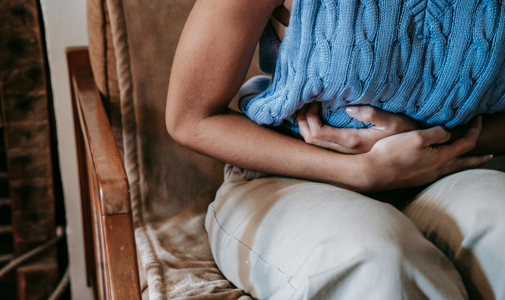 A woman clenches her stomach out of IBS pain