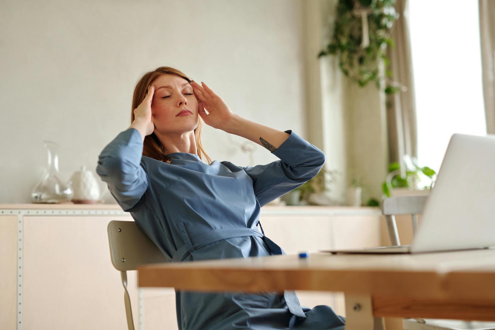 A woman touches her aching temples due to headache